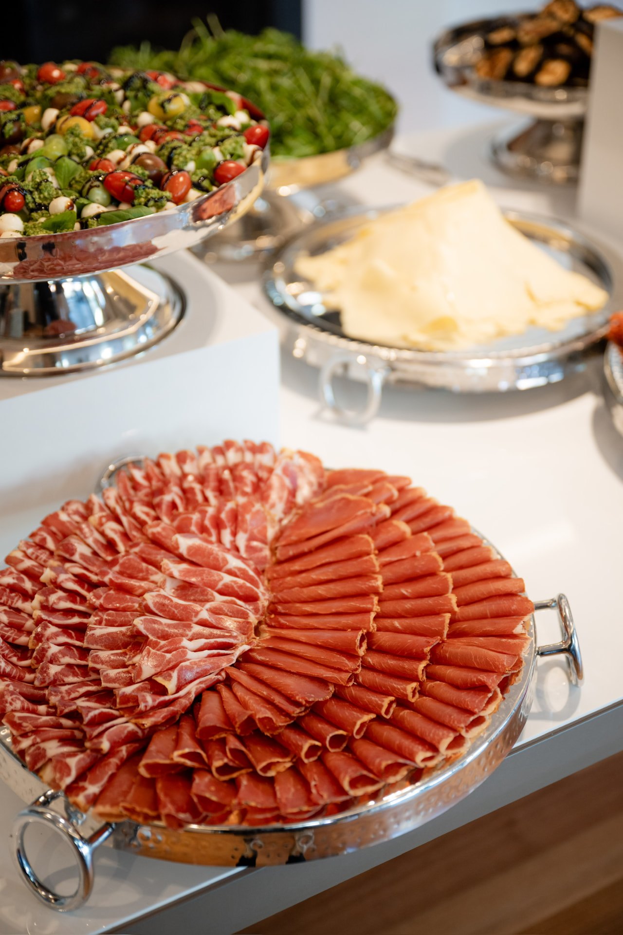 Fanned cured meats arranged on a round silver tray