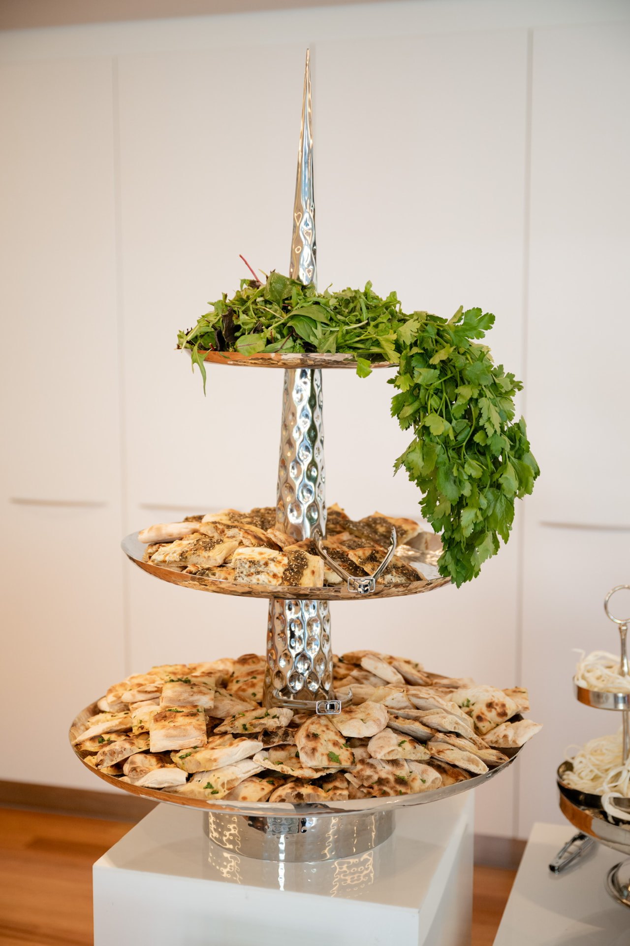 Tiered stand of sliced flatbreads finished with fresh herbs